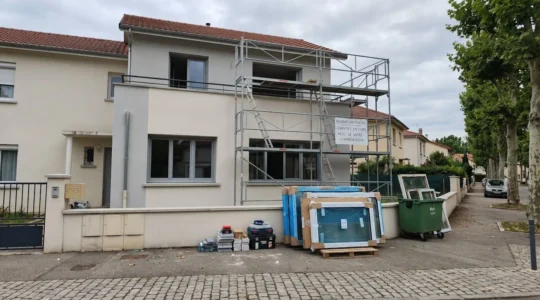 Façade d'une maison contemporaine française en cours de rénovation avec échafaudage installé pour le remplacement des menuiseries extérieures
